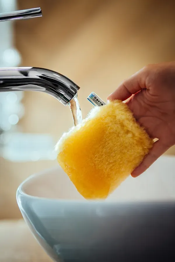 Żółta rękawiczka Face Cleaner Raypath zwilżana pod bieżącą wodą
