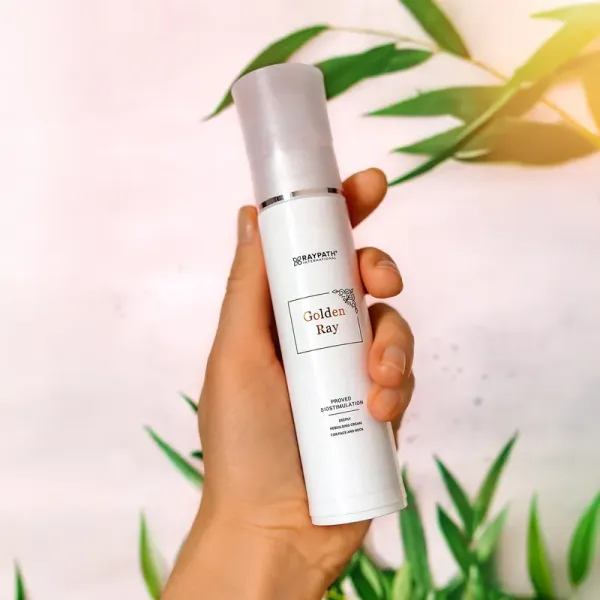 Biała butelka kremu Golden Ray Raypath 50 ml trzymana w dłoni
